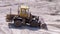 Old Tractor on Rubber Wheels Moves Sand Using a Bucket on Construction Site