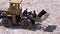 Old Tractor on Rubber Wheels Moves Sand Using a Bucket on Construction Site