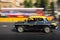 Old traditional black and yellow taxi in movement depicted with motion blur panning