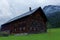 Old traditional country farmhouse in alpine region, misty scenery