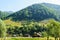 Old traditional house and barns in Rucar region, Romania. green hills covered in green forest in the background