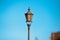 Old traditional metallic street lampposts with blue background