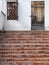 Old traditional porch with brick stairs and locked wooden door