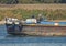 Old traditional river barge traveling through rural landscape