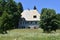 The old traditional stone house and the meadow full of flowers,maple trees