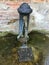 A old traditional water fountain found all over the city of Venice, Italy.  It supplies fresh cool drinking water