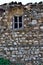 Old traditional wooden window in a ruined cobblestone house