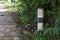 Old traffic barrier pillar beside dirty asphalt road in countryside in thailand