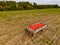 An old trailer full of red pumpkins lonely in a field as an aerial view