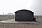 A old train carriage converted into a house with Dungeness Power Station in the background