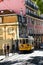 Old tram going through narrow streets in Lisbon