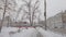 An old tram with passengers passes through the city street on a snowy winter day