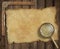 Old treasure map on wooden desk with loupe and