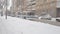 An old trolleybus with passengers passes through a city street on a snowy winter day