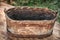 An old trough made from the bark of a tree. Vintage washtub woven from wood, with a metal rim at the bottom