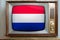Old tube vintage TV with the national flag of the Netherlands on the screen, stylish 60s interior, the concept of eternal values