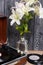 Old turntable. Several vinyl records and blossoming lilies against a background of black and white pine boards