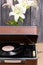 Old turntable. Several vinyl records and blossoming lilies against a background of black and white pine boards