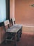 Old twin wooden chair on wooden terrace in front of room with glass window