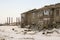 Old two-storied destroyed house in winter with snow around. Poverty and misery, North