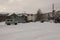 Old two-storied house in winter with snow, cars and trees on the yard. Poverty and misery, North