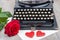 Old typewriter with a red rose