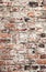 Old uneven decayed whitewashed shabby brick wall