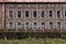 Old unused factory building facade with plenty of broken windows