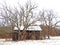 Old unused wood barn and trees in FingerLakes country during late winter
