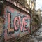 Old urban brick wall with pink graffiti street art word Love lettering.
