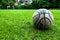 Old used ball on grass field