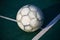 Old used football or soccer ball on cracked