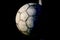 Old used football or soccer ball on cracked asphalt