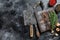 Old Used Meat Cleaver and knife with wooden cutting board. Black background. Top view. Copy space