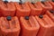 Old used orange jerrycans in mechanical workshop, full of old used oil ready to be recycled