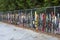 Old used skis and snow boards placed against a fence