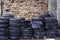 Old used tires stocked for recycling at red brick wall