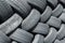 Old used weared car and truck wheels tyres pile stacked in rows stored for recycling. Heap of many rubber tires wall