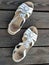 Old used white shoes / sandals on wooden floorboards