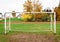 Old vacant football soccer goal gate in rural grass field.