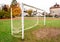 Old vacant football soccer goal gate in rural grass field.