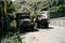 Old vehicles on rural road in mountains. Shabby trucks parked on old asphalt road in highland area on sunny day