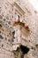 Old Venetian small balcony with white stone columns with beautiful patterns, rectangular clay pots and red blooming