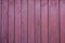 Old vertical pink wooden planks outdoors. Vintage rustic background texture