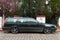 Old veteran dented big hatchback Swedish car dark green Volvo 850 parked