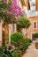 Old village alley with beautiful flowers and plants pots on Majorca island, Spain