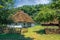 An old village wooden white house from 19th century with thatched roof.