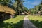 An old village wooden white house from 19th century with thatched roof.