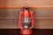 Old vinatge red kerosene oil lamp on wooden wall background