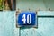 Old vintage blue house address metal plate number 40 forty on the rural gate